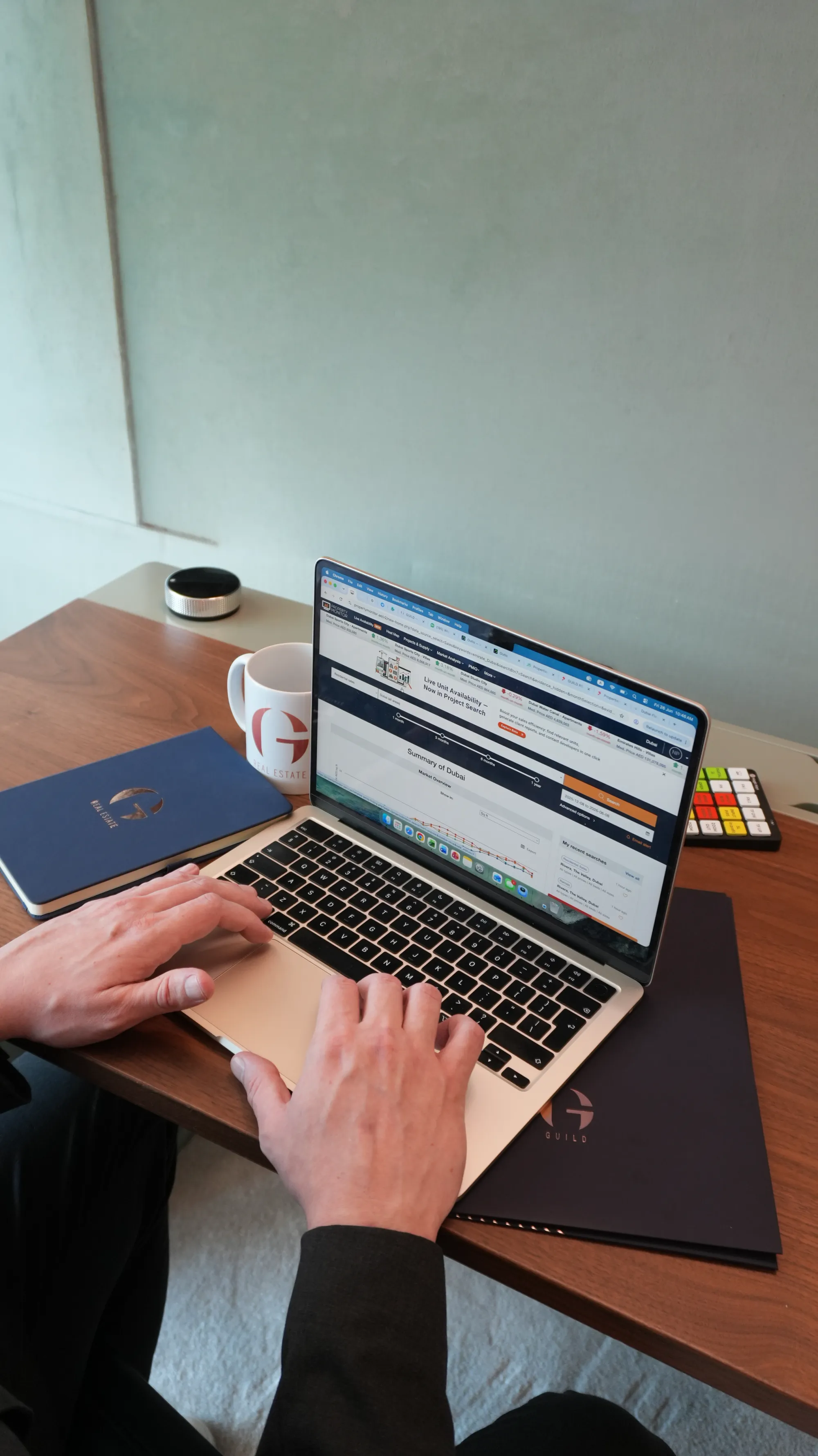A Guild consultant researching Dubai market data on a laptop